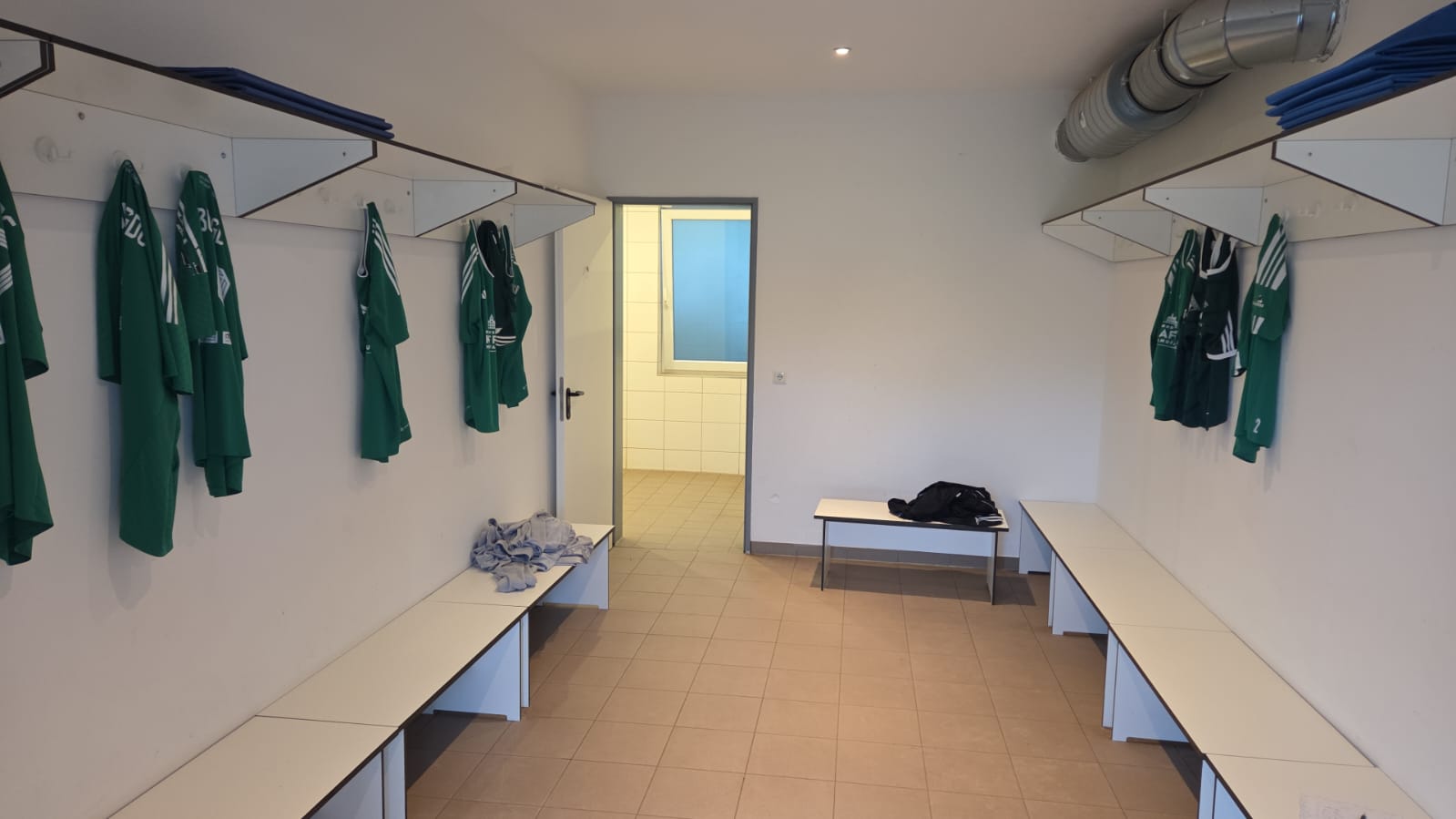 Umkleidekabine mit Sitzbänken und Trikots